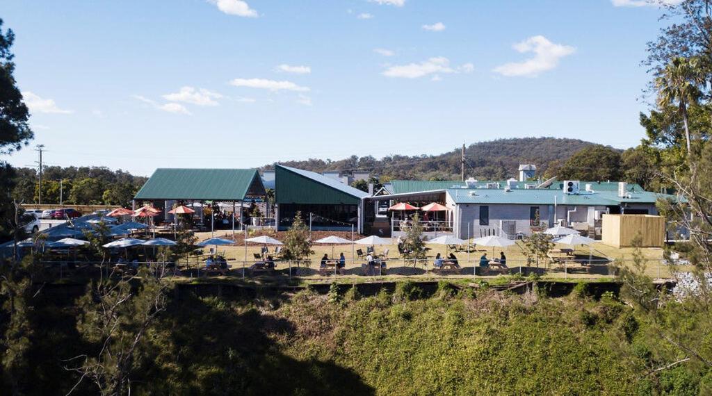 a restaurant with tables and chairs in front of a building at Coomera Lodge Hotel in Gold Coast