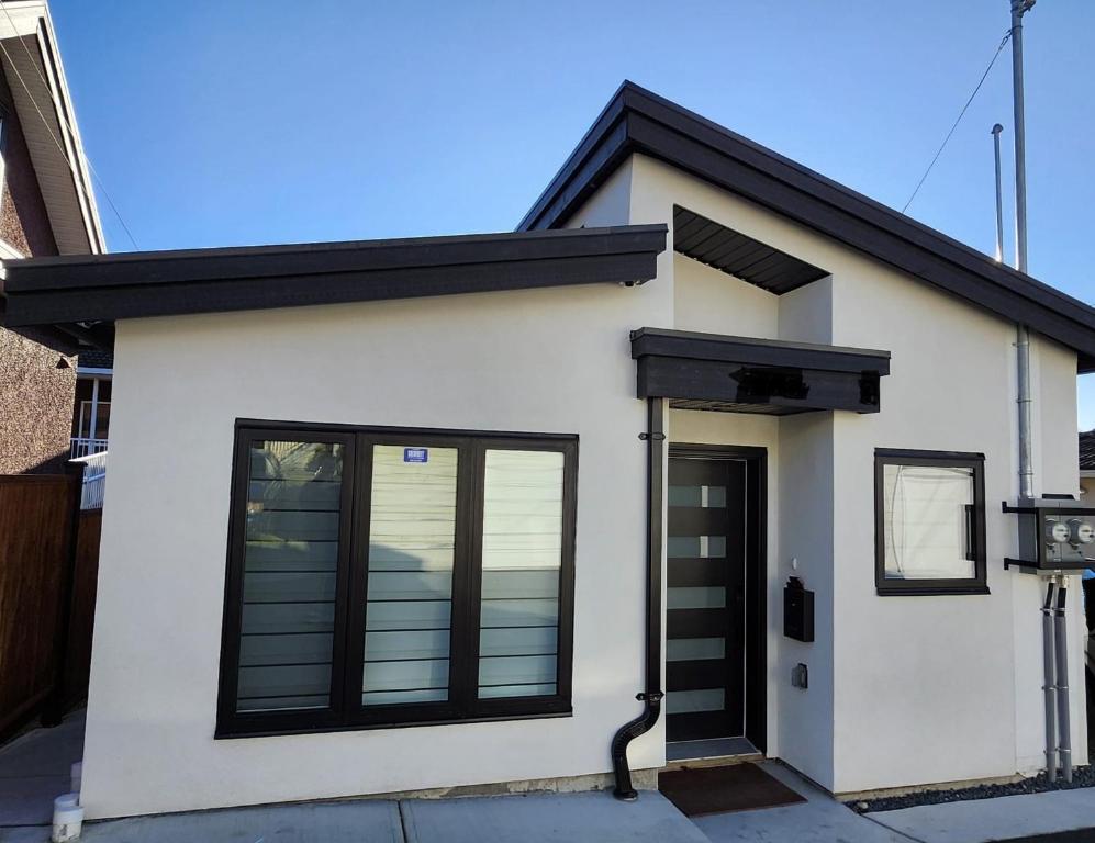 バンクーバーにあるCentral & Modern Whole House in Vancouverの黒い扉の小さな白い家