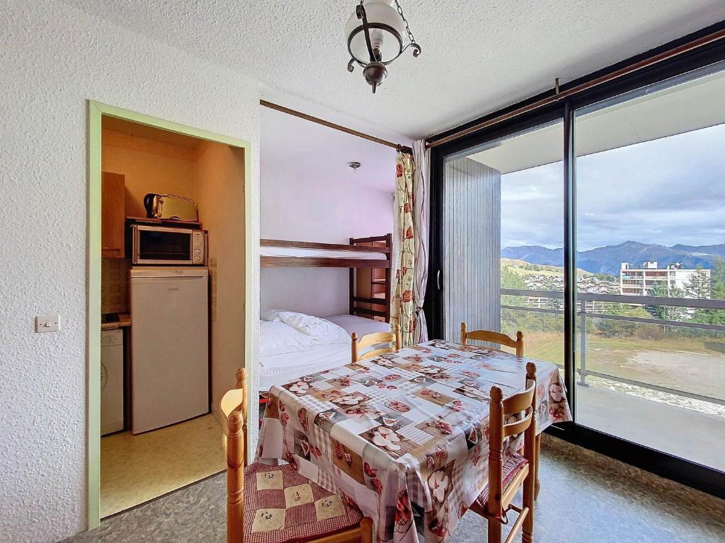 une chambre avec une table et une cuisine avec vue dans l'établissement Studio 4 pers au pied des pistes avec balcon à La Toussuire - FR-1-416-236, à La Toussuire