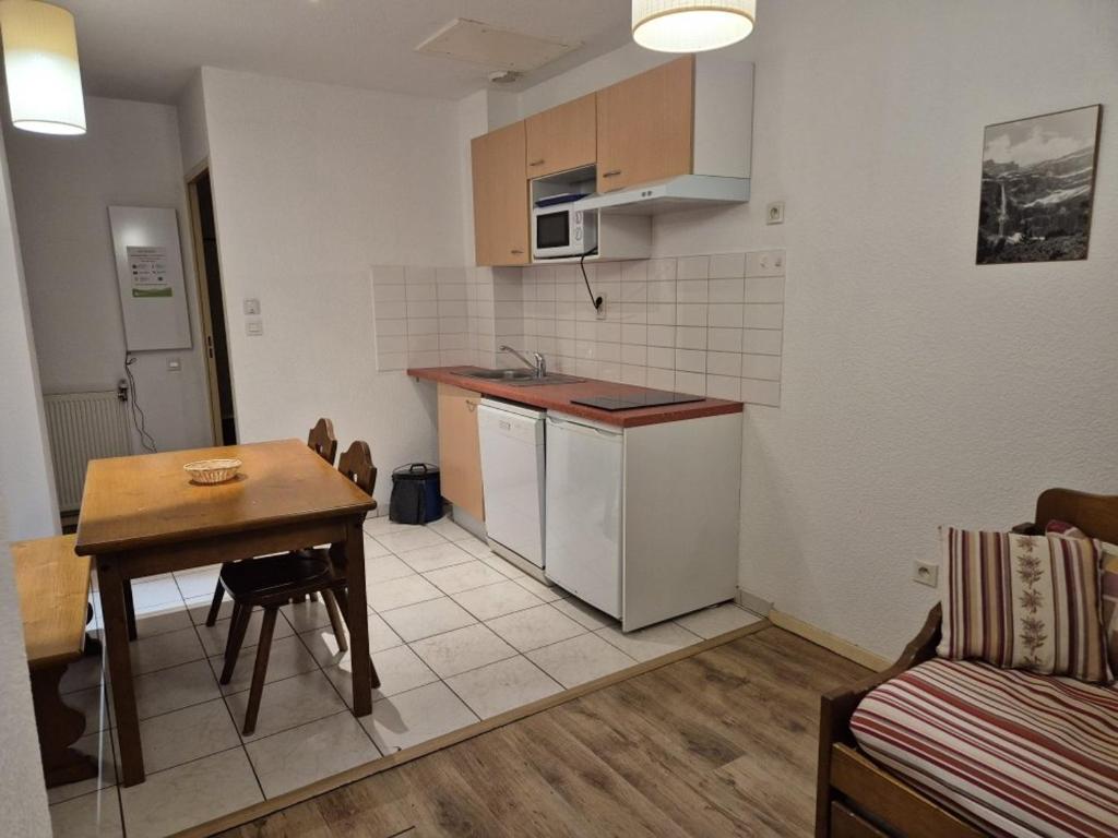 - une petite cuisine avec une table et un comptoir dans l'établissement Appartement T2 avec Terrasse et Parking à Cauterets - FR-1-234-337, à Cauterets
