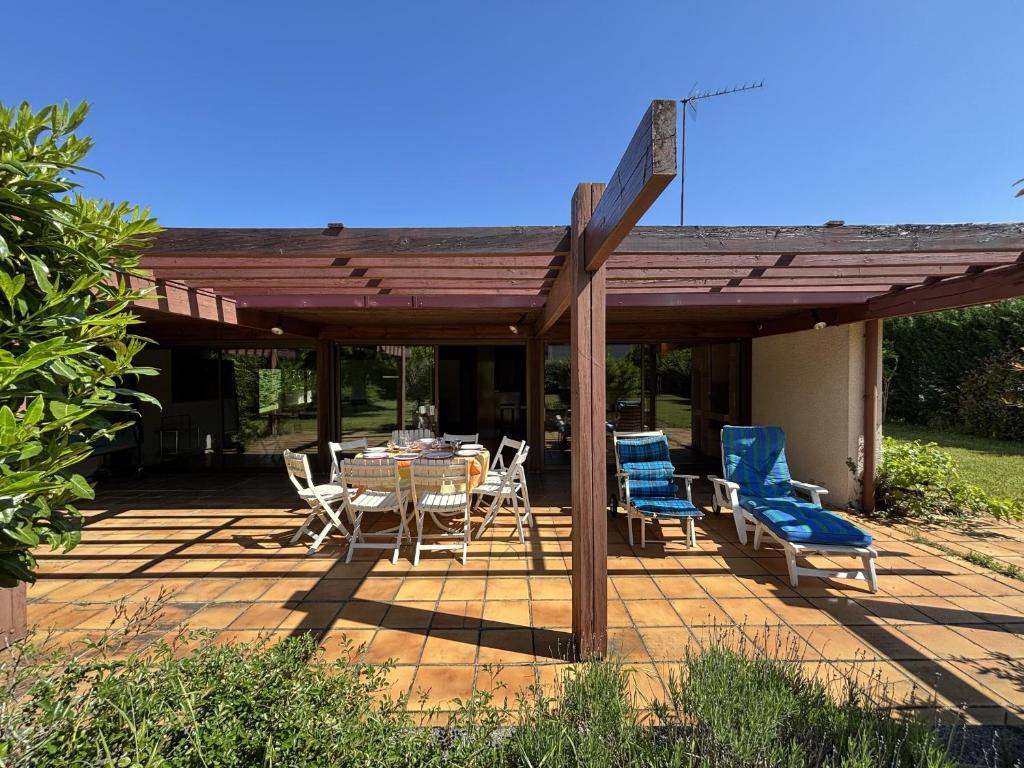 une pergola en bois avec une table et des chaises sur une terrasse dans l'établissement Maison Landaise d'Architecte - 8 Pers - Biscarrosse Bourg - FR-1-319-609, à Biscarrosse