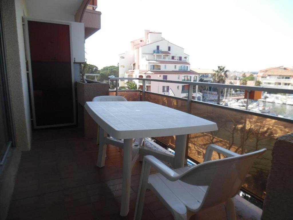 une table blanche et des chaises sur un balcon dans l'établissement Appartement traversant 2 pièces, 4 pers, loggias, parking, proche plage - FR-1-750-97, à Canet