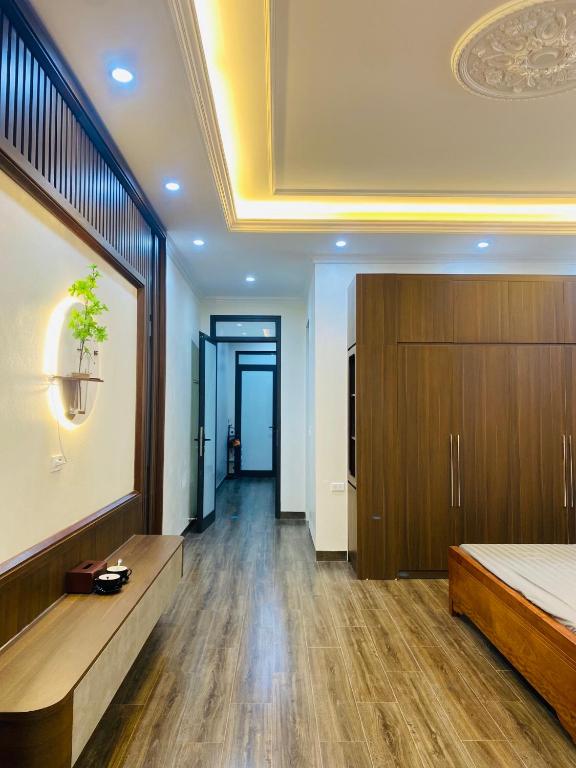 a bedroom with a bed and wooden floors and a ceiling at Phòng lưu trú du lịch nhà phố trung tâm in Ða Gia