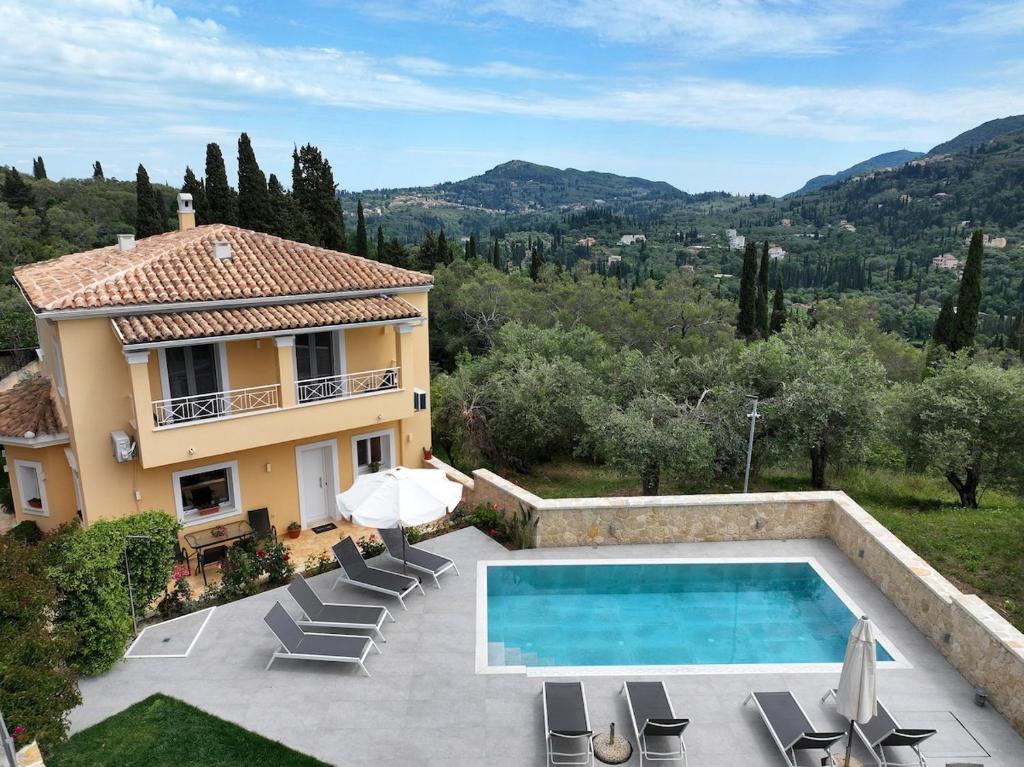a villa with a swimming pool in front of a house at Villa Eoli Corfu in Ágios Prokópios