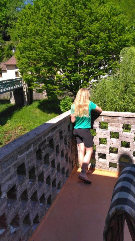 une femme marchant sur un pont de pierre dans l'établissement Chez Alain, à Fontenoy-le-Château