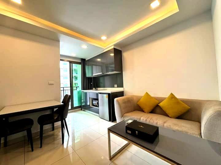 a living room with a couch and a table at Modern 1-Bedroom Condo with Pool View Arcadia Beach Continental Pattaya in Pattaya South