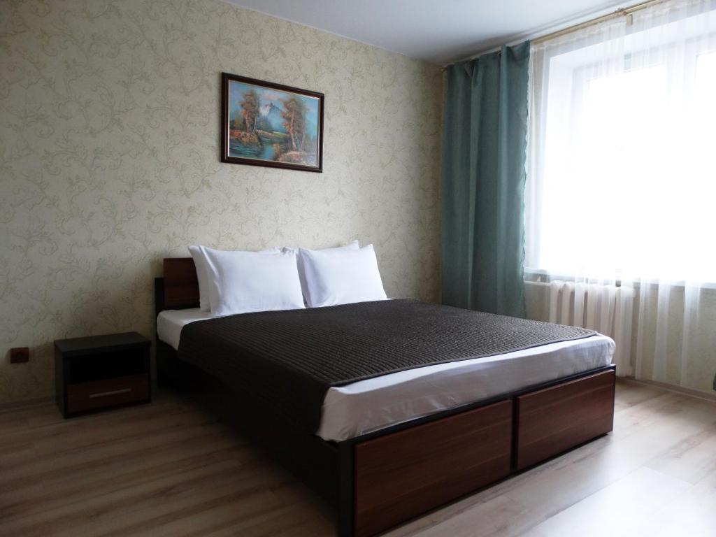 a bedroom with a large bed with a window at InnDays on Sportivnaya in Moscow
