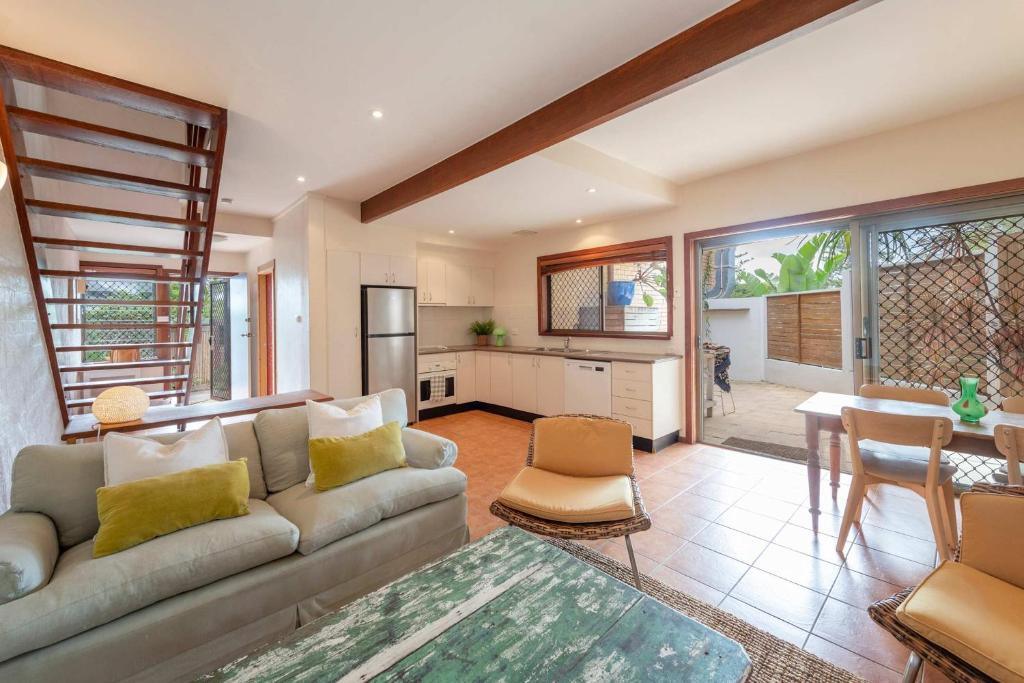 a living room with a couch and a kitchen at Spooky Beach Lodge - Oceanstays in Yamba