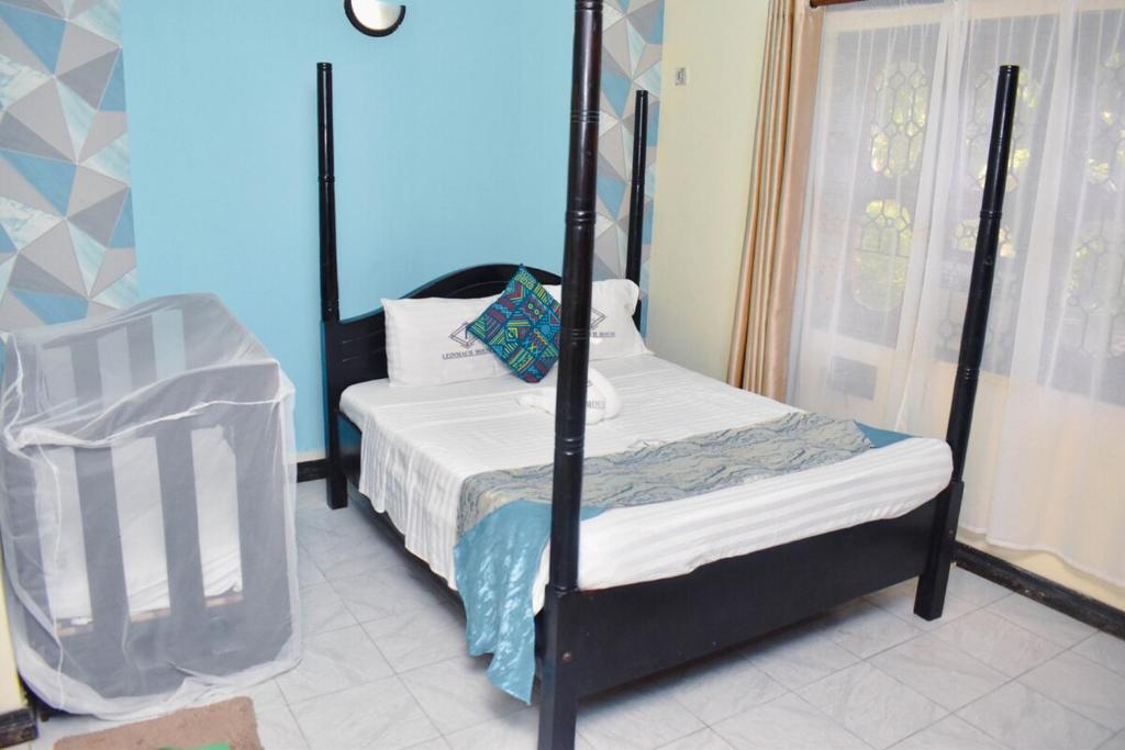 1 dormitorio con cama con dosel y ventana en One Bedroom with 3 beds can sleep 4, en Mombasa