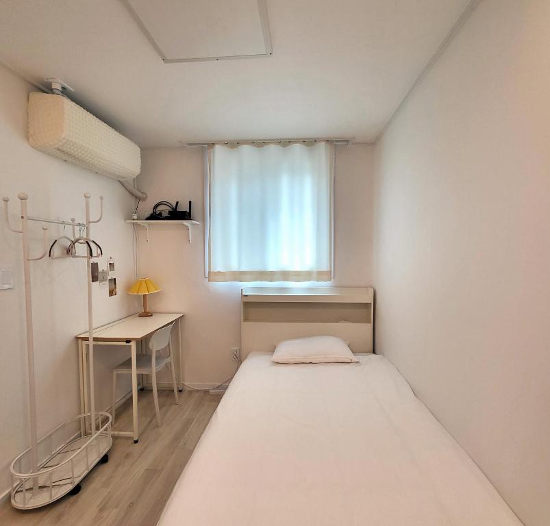 a small room with a bed and a window at Humming stay in Seoul