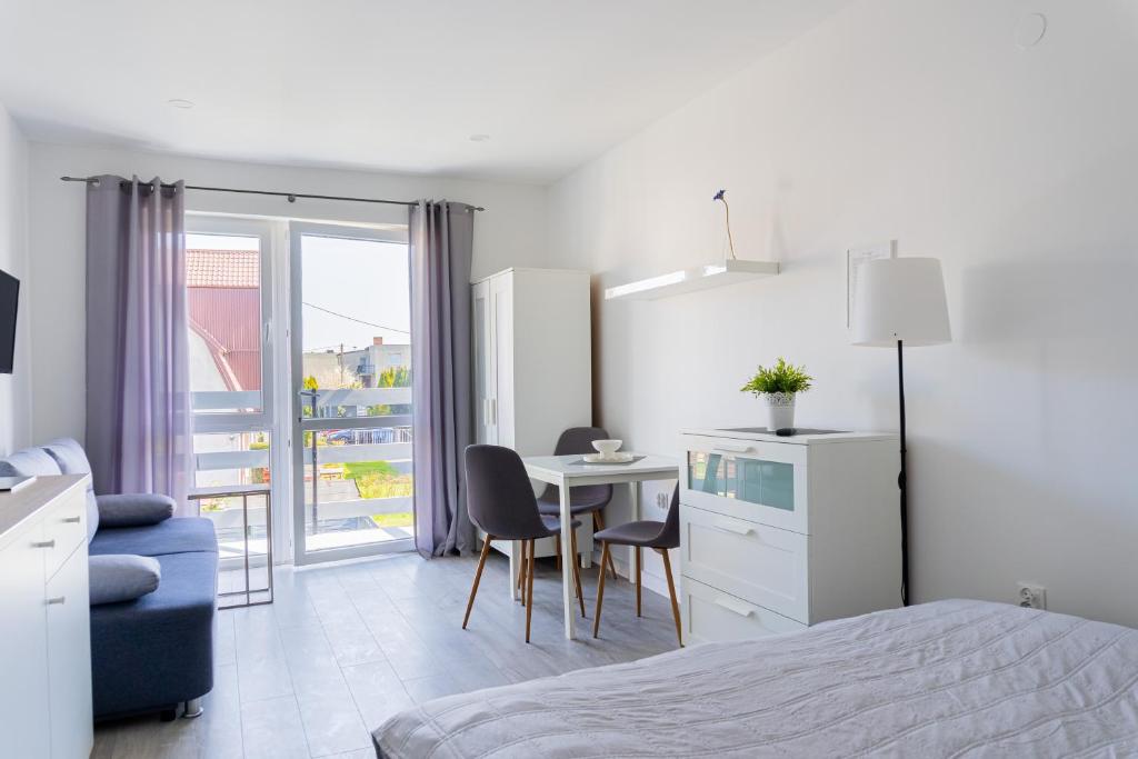 a bedroom with a bed and a table and chairs at Leśny Karwia - Pokoje 70m od Plaży in Karwia