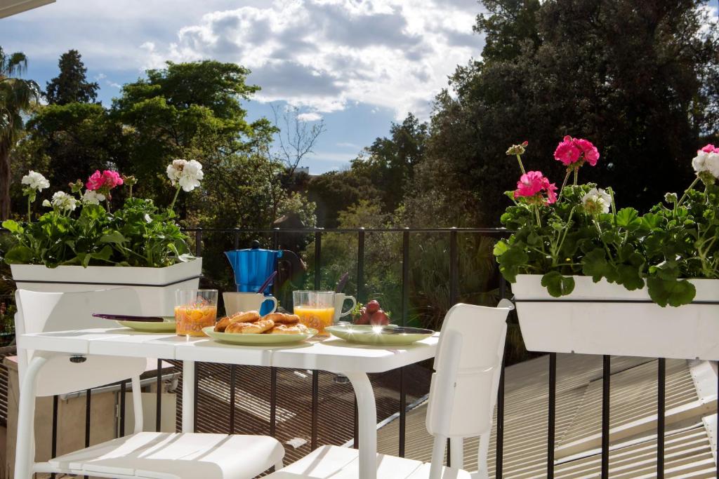 a white table and chairs on a deck with flowers at Apartments Carmen III in Valencia