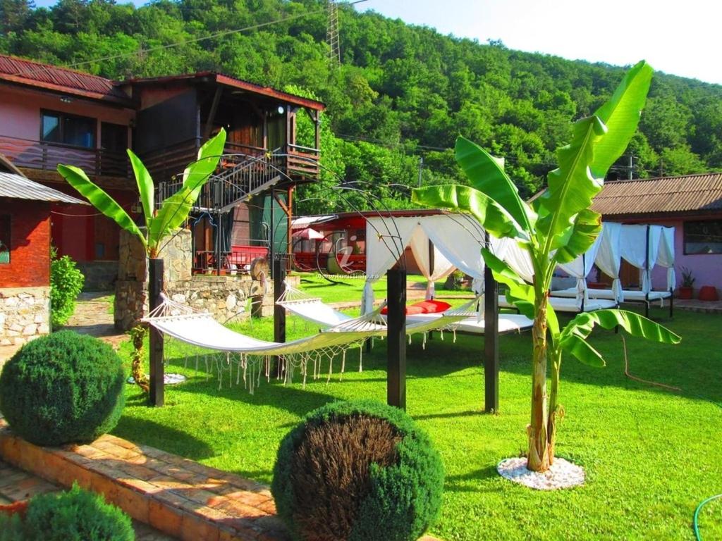 a resort with a hammock in front of a house at Cabana Ogradena in Eşelniţa