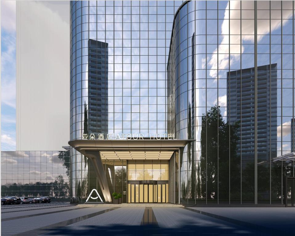Atour Hotel Wuxi Baolong Plaza Changjiang Road في ووشي: مبنى زجاجي كبير امامه بوابة