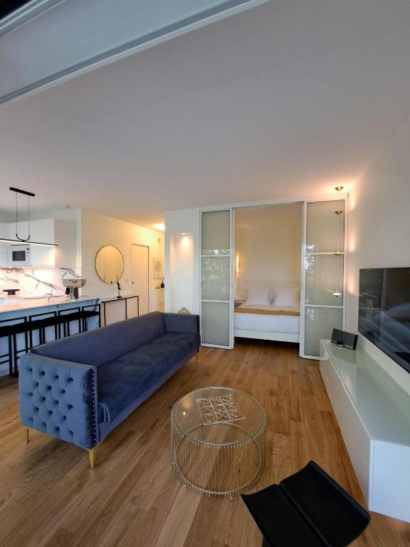 un salon avec un canapé bleu et une table dans l'établissement La Croisette Côté Lac, à Créteil