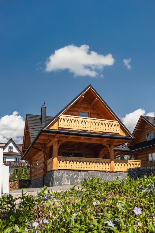 a large wooden house with a balcony on it at Czorsztyn View Chalets in Czorsztyn