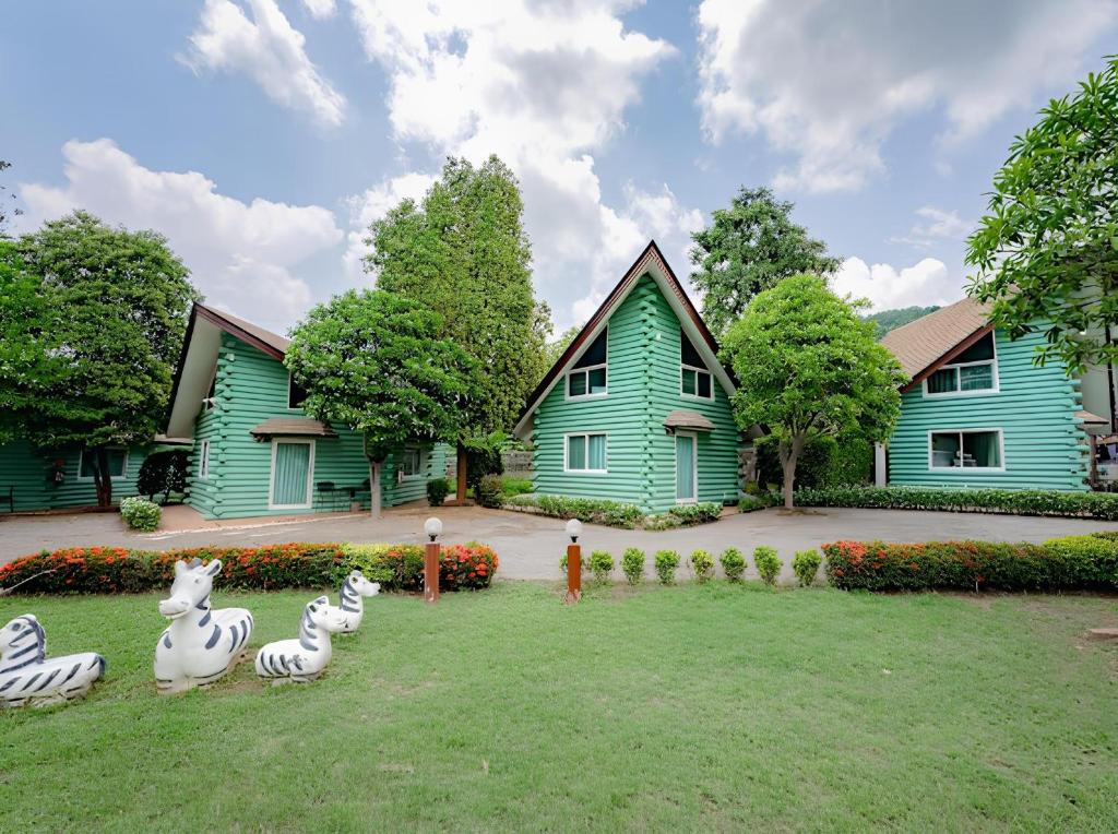 ein Haus mit einigen Tieren im Hof in der Unterkunft Rockwood house Resort and Thai massage ร็อควู้ด เฮาส์ รีสอร์ท แอนด์ ทรงวาดนวดแผนไทยเพื่อสุขภาพ และสปา in Pak Chong
