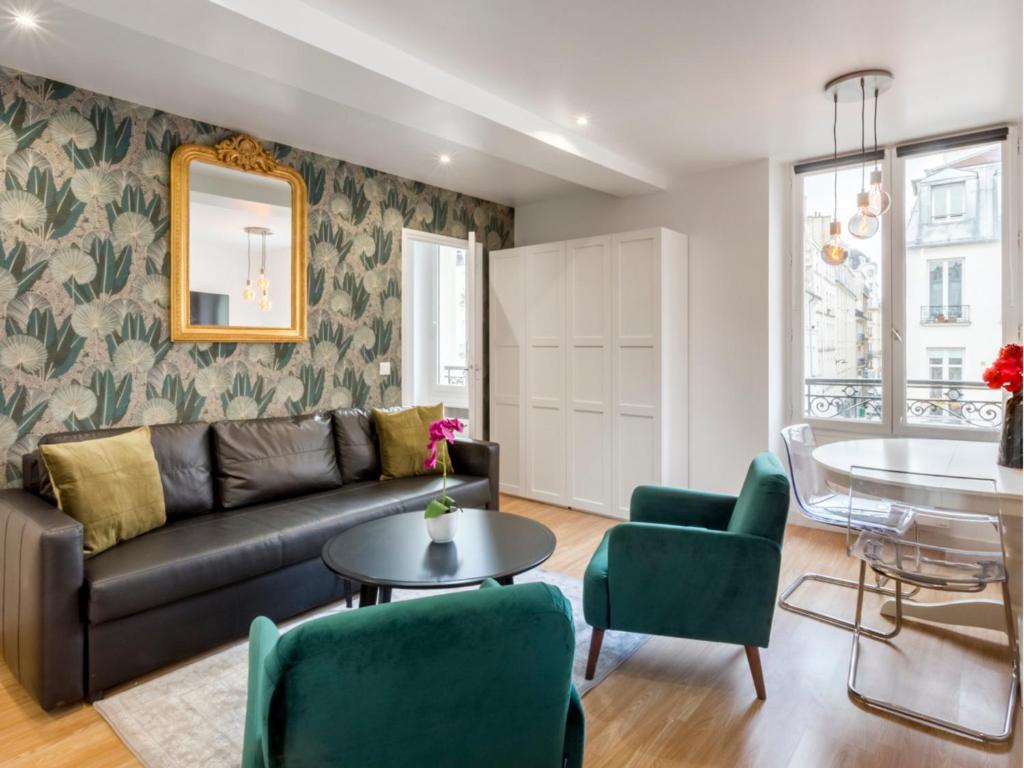un salon avec un canapé, une table et des chaises dans l'établissement Merveil - Family Suite - Marais - Martin VI, à Paris