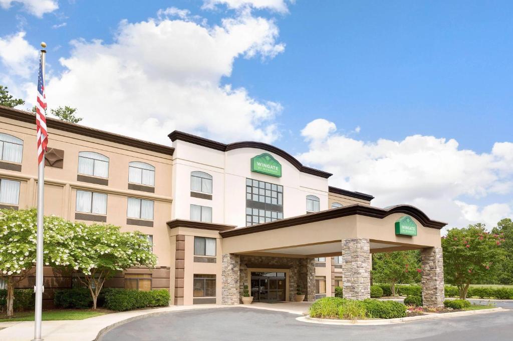 una imagen de la parte delantera de un hotel con bandera americana en Wingate by Wyndham Raleigh Durham &#47; Airport, en Durham