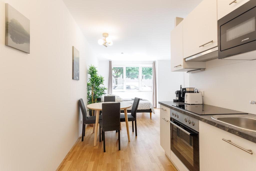 a kitchen and dining room with a table and chairs at Central Modern Studio Apartment with Free Parking in Vienna