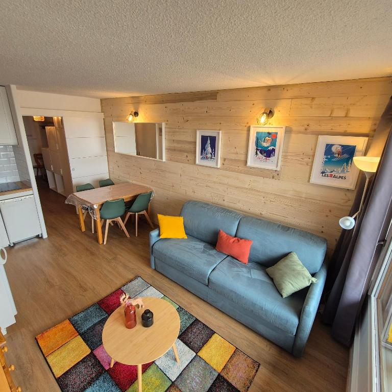 un salon avec un canapé bleu et une table dans l'établissement APPARTEMENT RESIDENCE PLEIN SUD , CENTRE STATION , PIED DES PISTES , PARKING ,WIFI , 30 m2 , 4p, à Les Deux Alpes