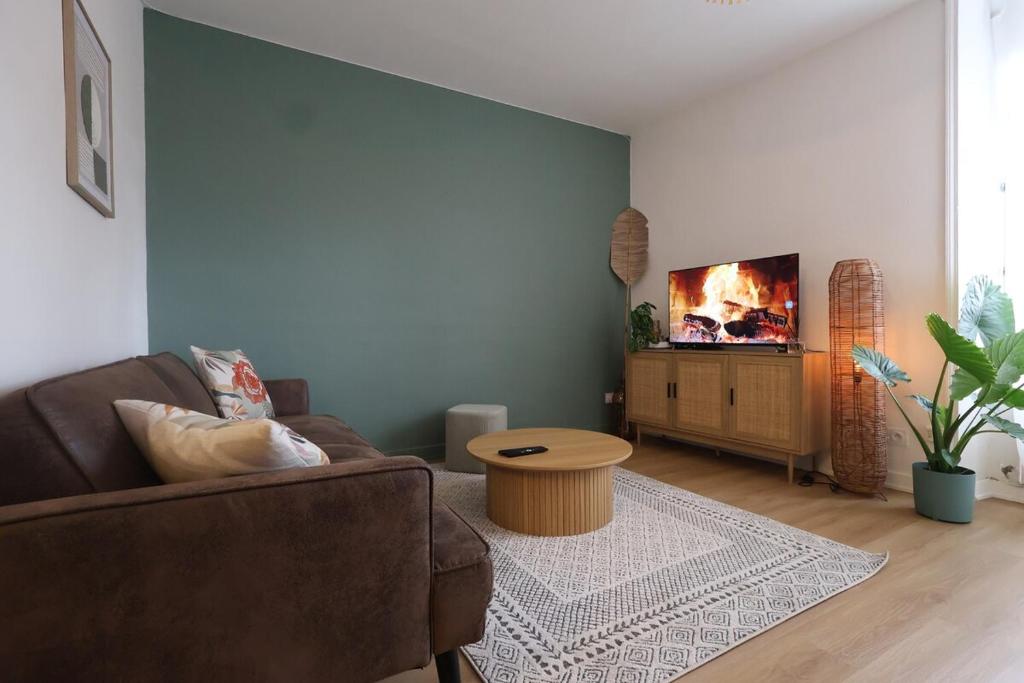 un salon avec un canapé et une table dans l'établissement Vernouillet charmant T3 situé à deux pas du centre, à Reims