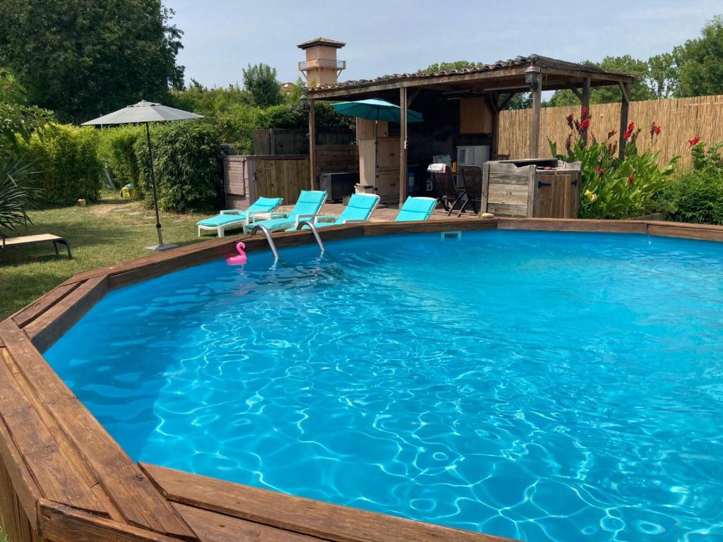 a swimming pool with chairs and a gazebo at loft appartement dans bastide in La Celle-sous-Gouzon