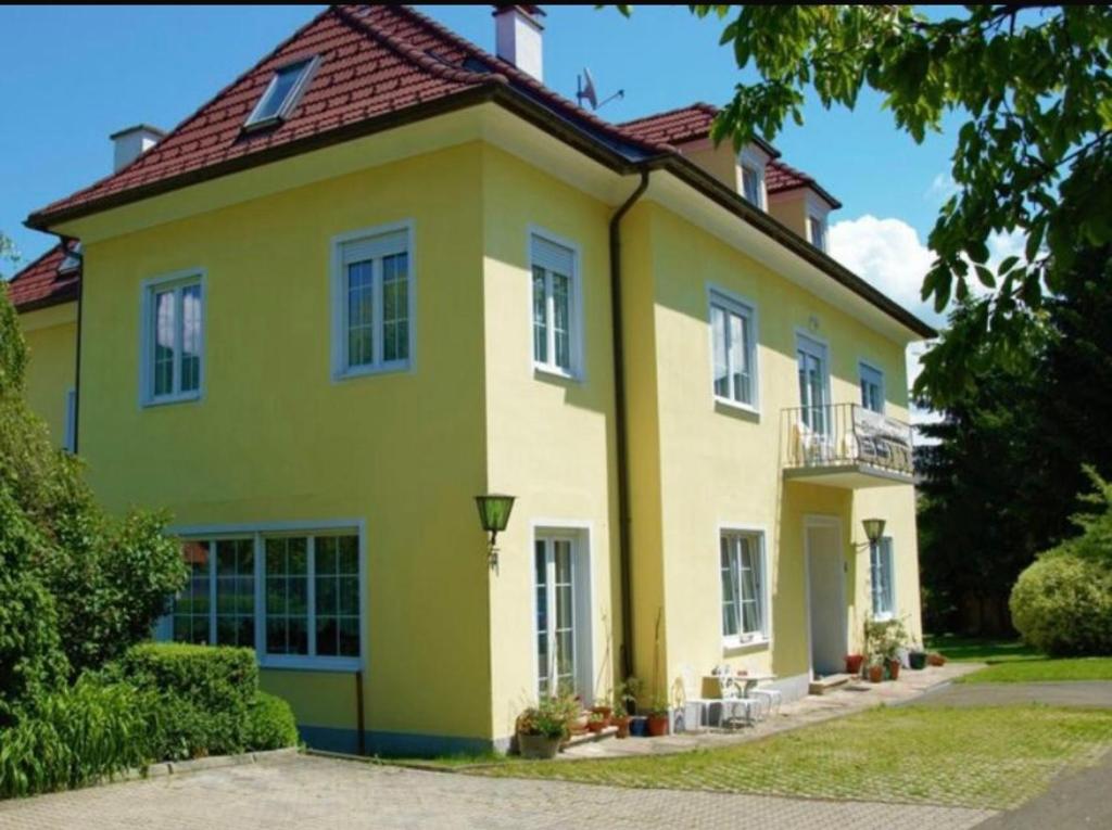 a yellow house with a red roof at Gästehaus Steiner in Spielberg
