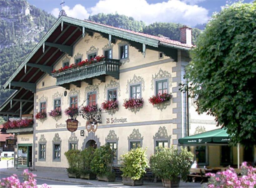 a building with flower boxes on the side of it at Gasthof Falkenstein - Metzgerei Schwaiger - in Flintsbach