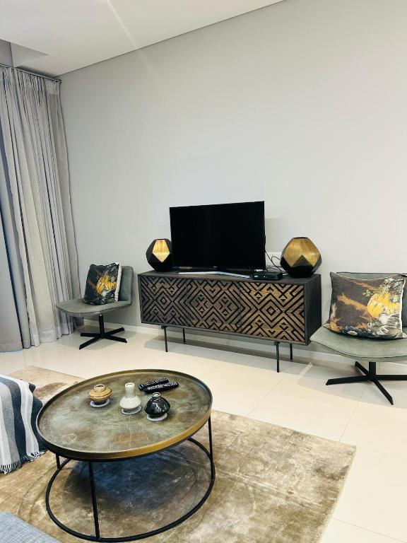 a living room with a tv and a coffee table at Itowers Luxury Apartment in Gaborone