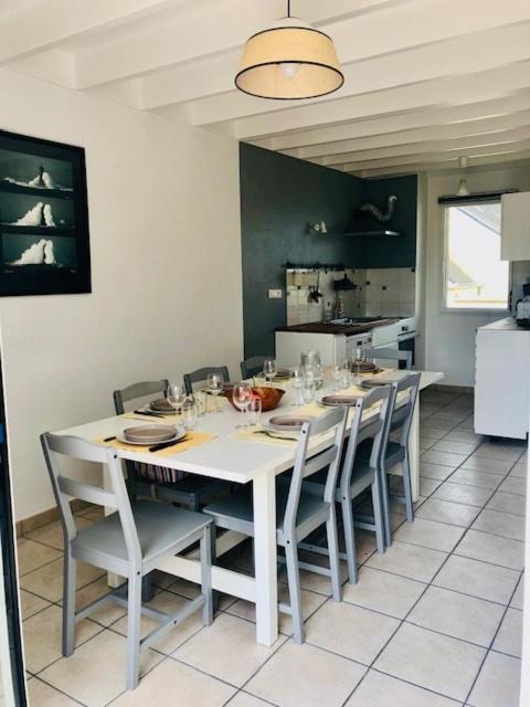 une salle à manger avec une table et des chaises blanches dans l'établissement Le Galion Beach, au Croisic
