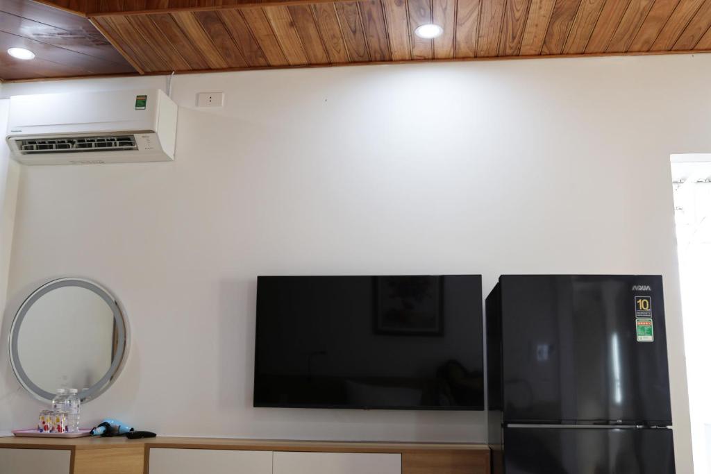 a kitchen with a black refrigerator and a mirror at Khách sạn Phan văn 1 in Danang