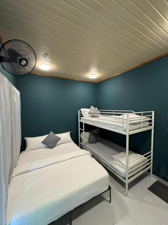 a bedroom with two bunk beds and a blue wall at Woodstock Camp Chalet in Bentong