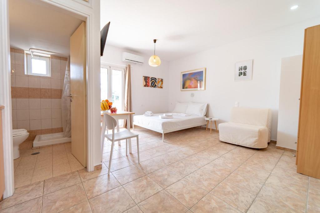 a living room with a bed and a bathroom at Beachfront Cozy Apartments in Amoudara Herakliou