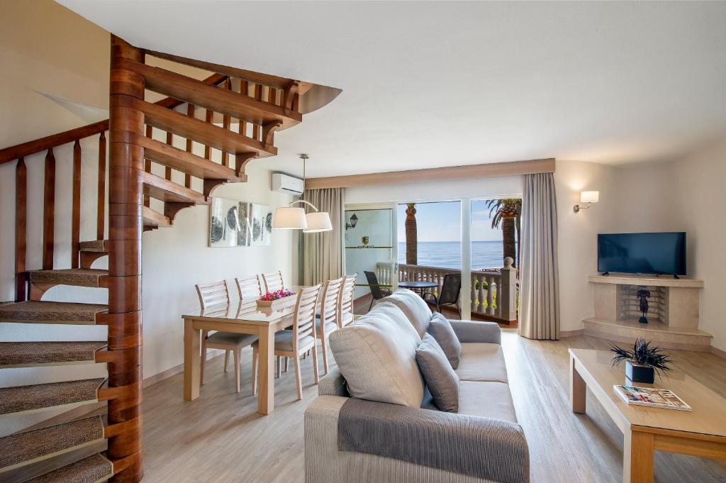 a living room with a couch and a table at Macdonald Leila Playa Resort in La Cala de Mijas