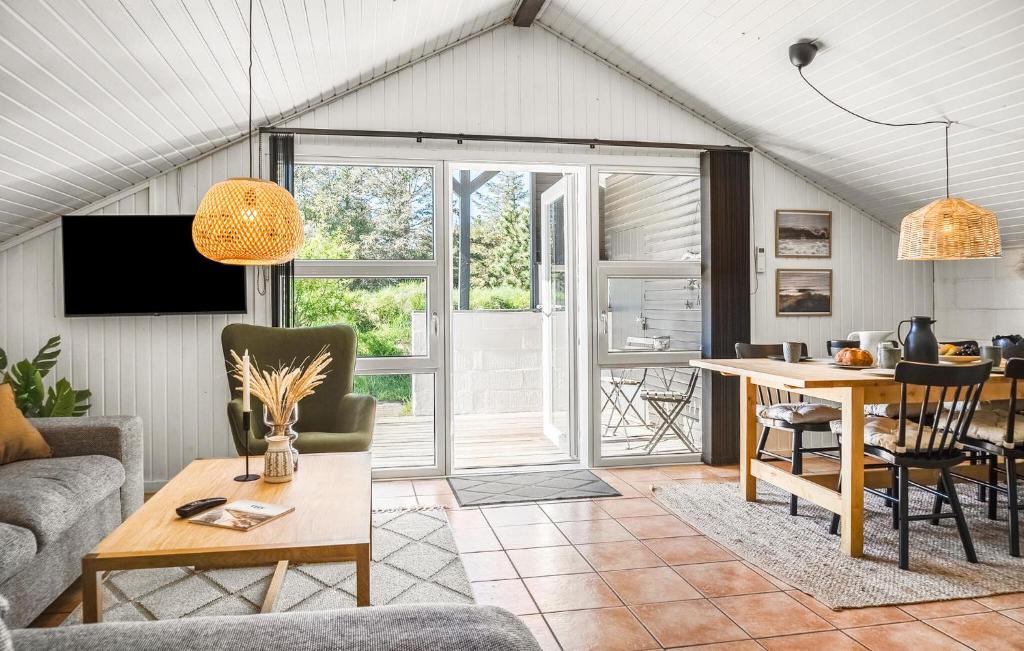 a living room with a table and a dining room at Three-Bedroom Holiday Home In Thisted in Nørre Vorupør