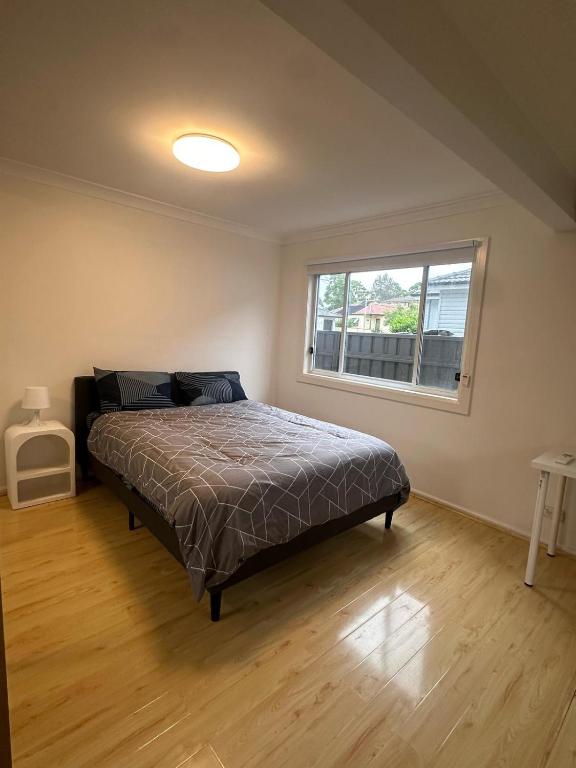 a bedroom with a bed and a window at Comfortable and Spacious Queen Room - SW2 in Wentworthville