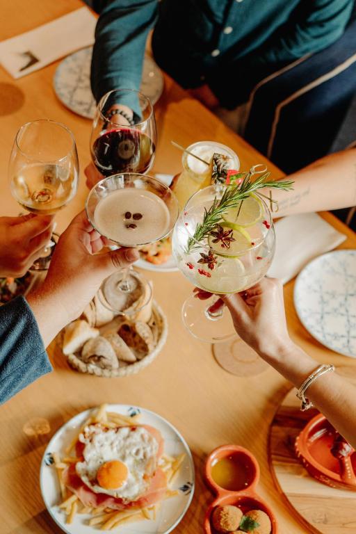 a group of people holding glasses of wine and food on a table at Velamar Boutique Hotel - Adults Friendly in Albufeira