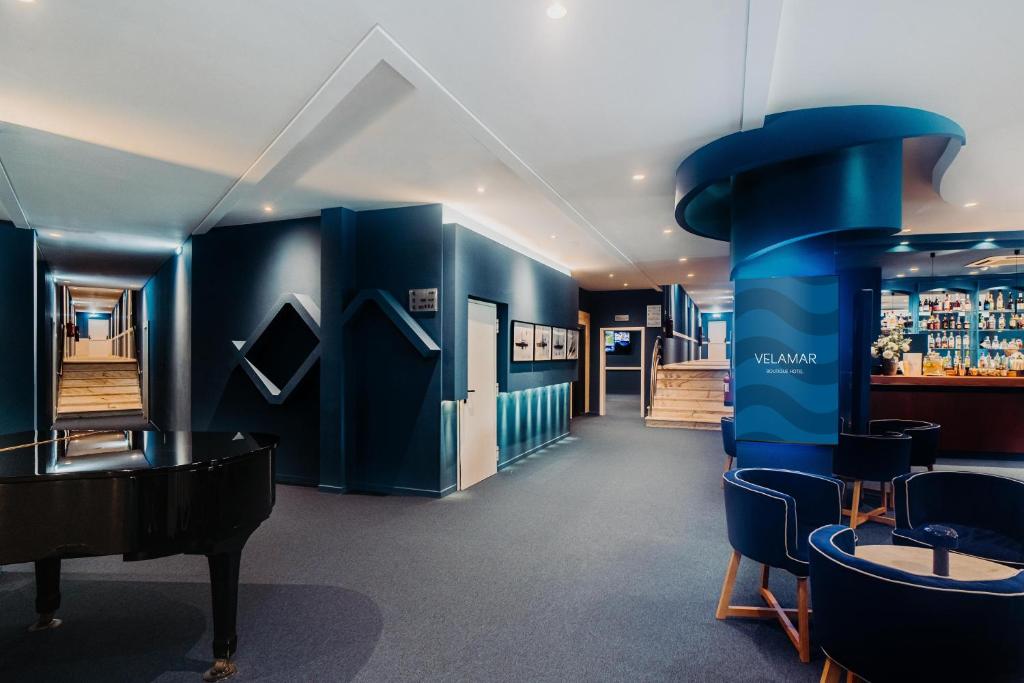 a room with blue walls and a piano and chairs at Velamar Boutique Hotel - Adults Friendly in Albufeira