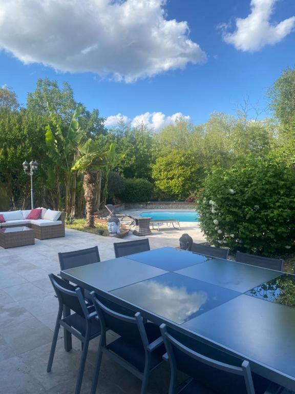 a patio with a table and chairs and a pool at Toulousaine de 200 m2 10 pers Piscine proche de Toulouse in Lagrâce-Dieu