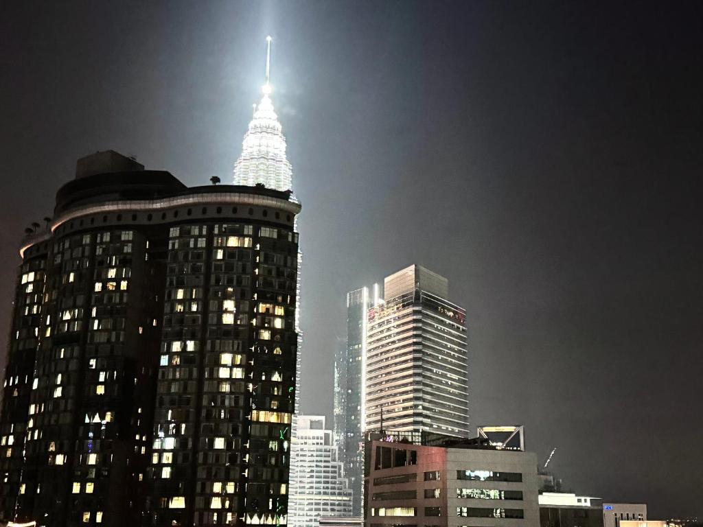 a view of a tall building in a city at night at Vortex Suites Klcc 2bedroom & 3bedroom apartment in Kuala Lumpur