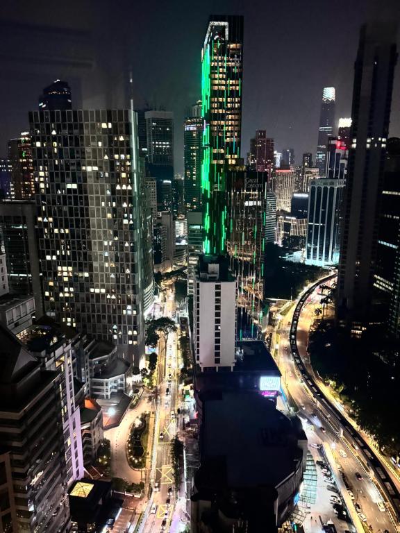 a city lit up at night with traffic at Vortex Suites Klcc 2bedroom & 3bedroom apartment in Kuala Lumpur
