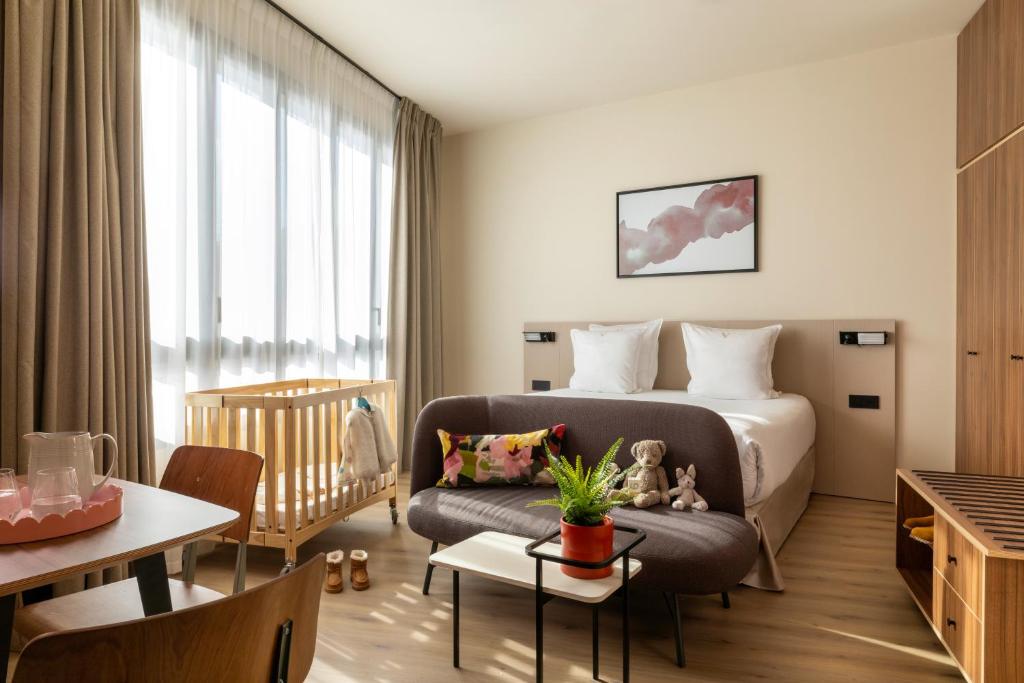 ein Hotelzimmer mit einem Bett und einer Couch in der Unterkunft Yuna Montmartre - ApartHotel in Paris