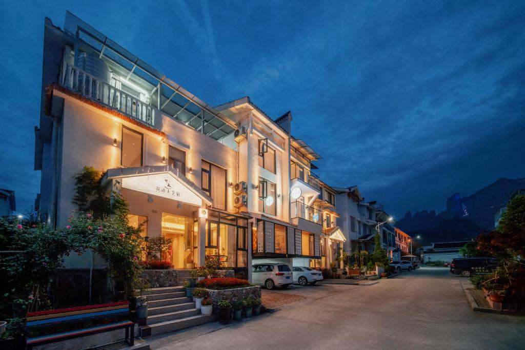 a large building with a car parked in front of it at Flower Whisperer Homestay Tianmenshan Store free airport and station pick-up in Zhangjiajie