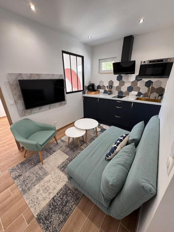 - un salon avec un canapé vert et une télévision dans l'établissement Logement cosy avec terrasse, à Villeparisis