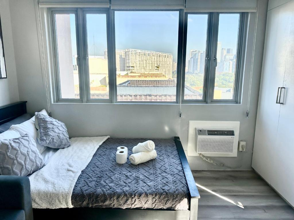 a bedroom with a bed with two stuffed animals on it at Modern and Slick Condo in Venice near Makati and BGC in Sampong
