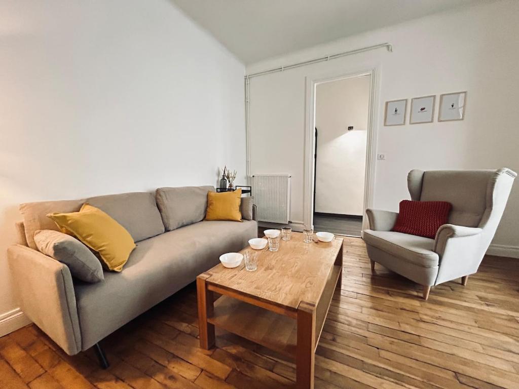 un salon avec un canapé, une table et des chaises dans l'établissement Jadart T3 avec balcon au pied de la cathédrale, à Reims