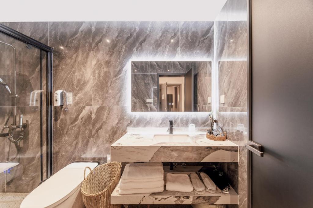 a bathroom with a sink and a mirror at Flower Whisperer Homestay Tianmenshan Store free airport and station pick-up in Zhangjiajie