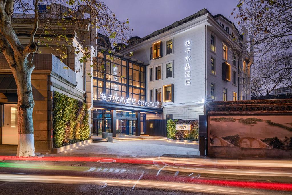um edifício numa rua à noite com luzes em 杭州西湖桔子水晶酒店 em Hangzhou