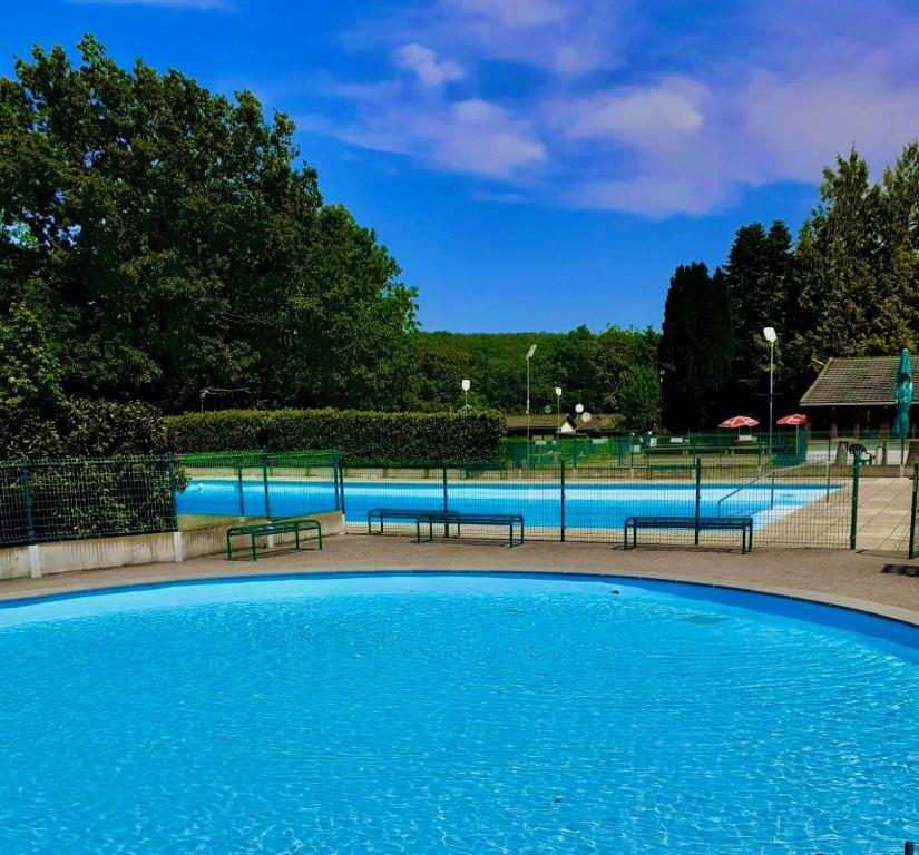 a large swimming pool with benches in a park at Chalet 5 personnes avec piscine in Yvoir